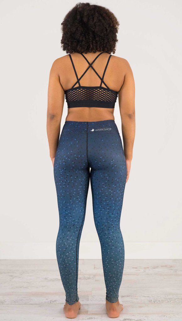 Back view of model wearing WERKSHOP Black Ombre Full Length Triathlon Leggings. The artwork is dark indigo blue on top and fades to a lighter blue on the bottom - with a lot of texture from bead-like artwork.