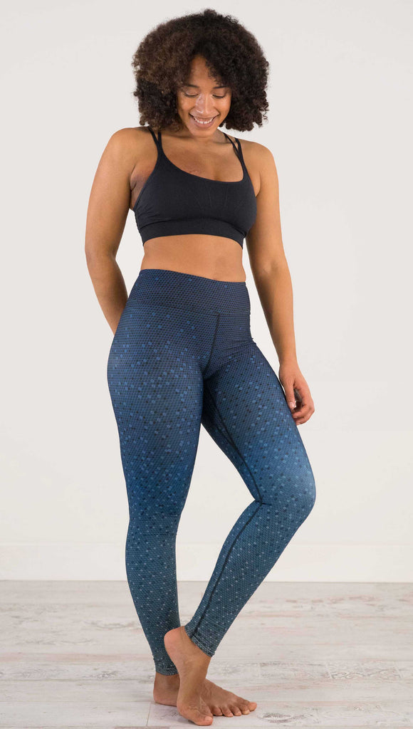 Full body, side view of model wearing WERKSHOP Black Ombre Full Length Triathlon Leggings. The artwork is dark indigo blue on top and fades to a lighter blue on the bottom - with a lot of texture from bead-like artwork.