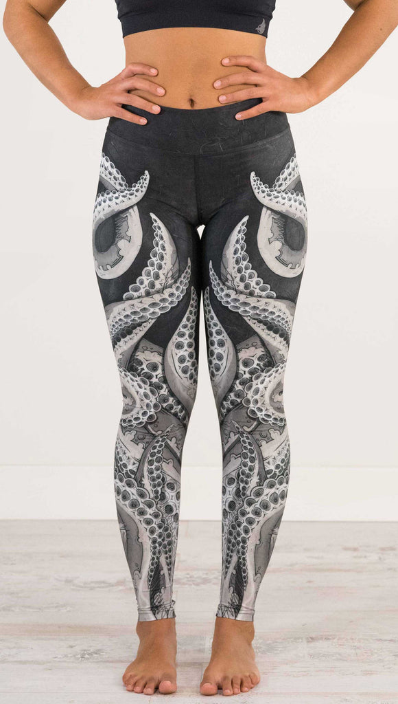 Waist down view of model wearing WEKSHOP Tentacles Full Length Triathlon Leggings. The artwork is monochrome black and white and features large tentacles wrapping around the legs from the bottom reaching upward.