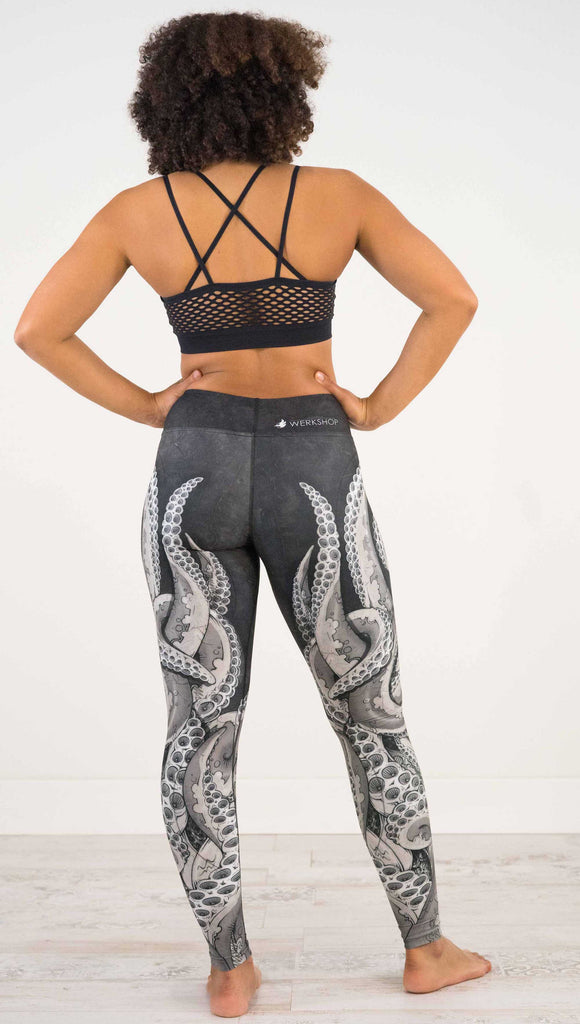 Back view of model wearing WEKSHOP Tentacles Full Length Triathlon Leggings. The artwork is monochrome black and white and features large tentacles wrapping around the legs from the bottom reaching upward.