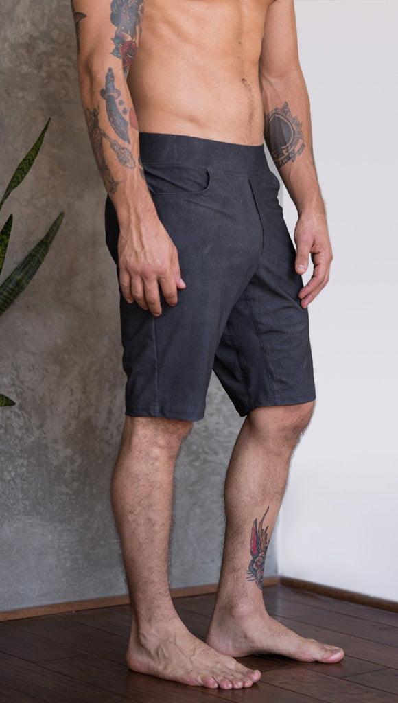 closeup right side view of model wearing charcoal black printed mens performance shorts