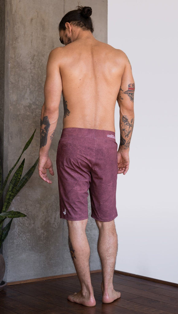 back view of model wearing brick red printed mens performance shorts