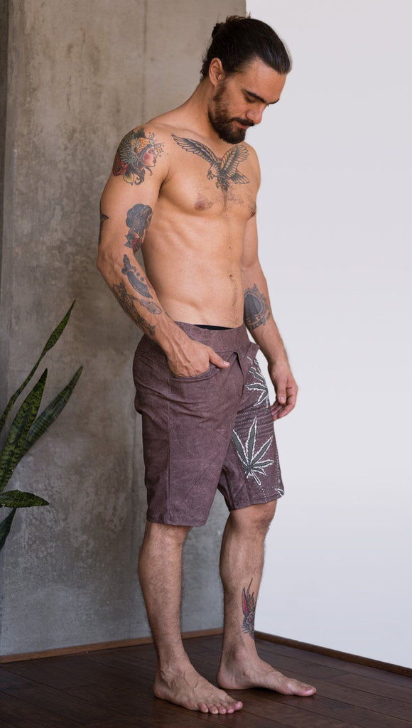right side view of model wearing cannabis inspired printed mens performance shorts