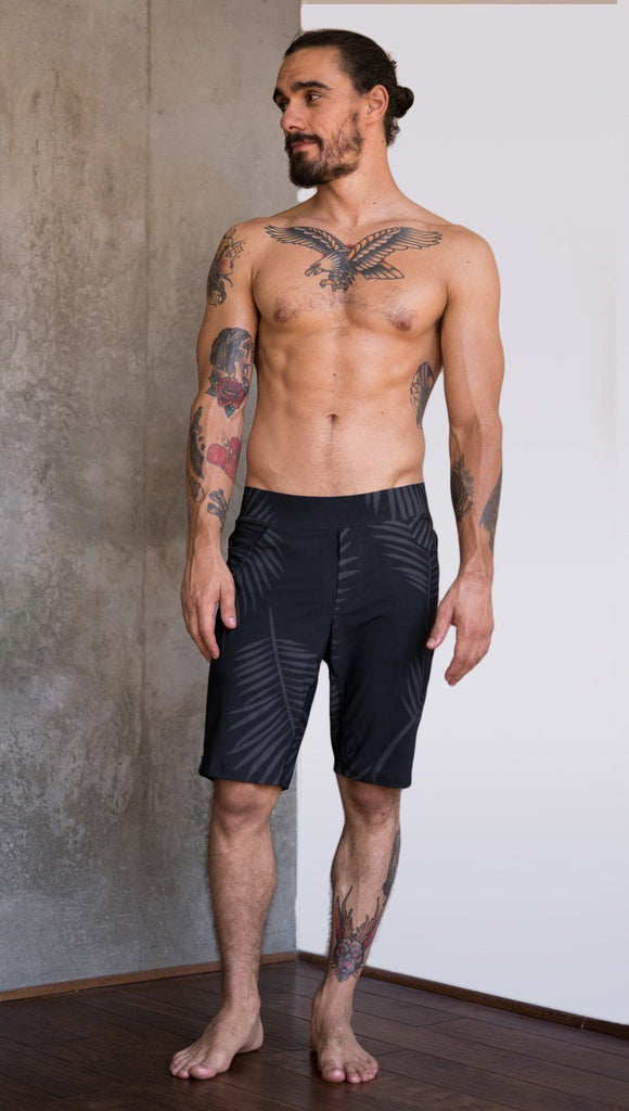 front view of model wearing tropical palm fronds printed mens performance shorts