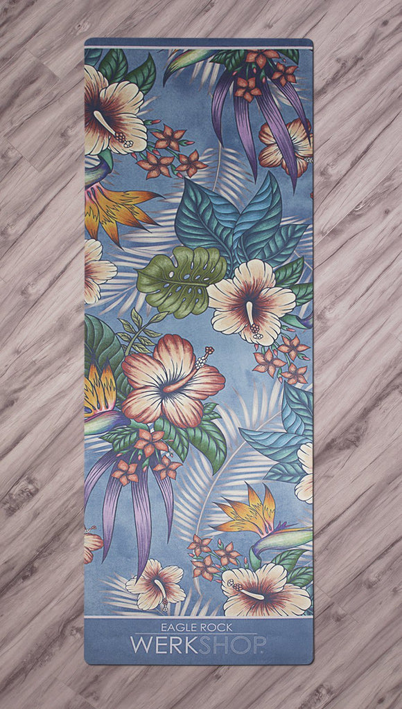 top view of yoga mat with tropical floral design and blue background
