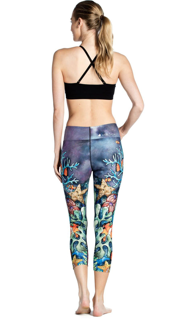 back view of model wearing coral reef themed printed capri leggings