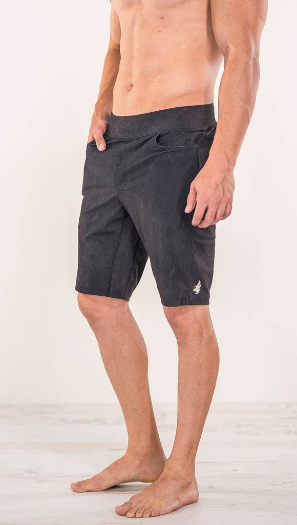 Close up right side view of model wearing charcoal black printed men's performance shorts