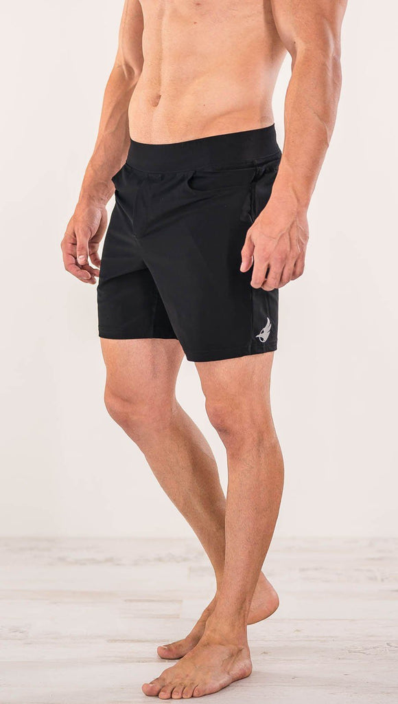 Close up right side view of model wearing black men's performance shorts
