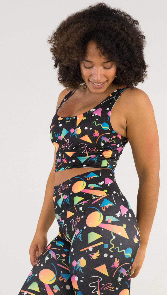Side view of model wearing WERKSHOP Black and White Confetti Top ... with multi-colored confetti  over a black background on one side and over a white background on the other side. 