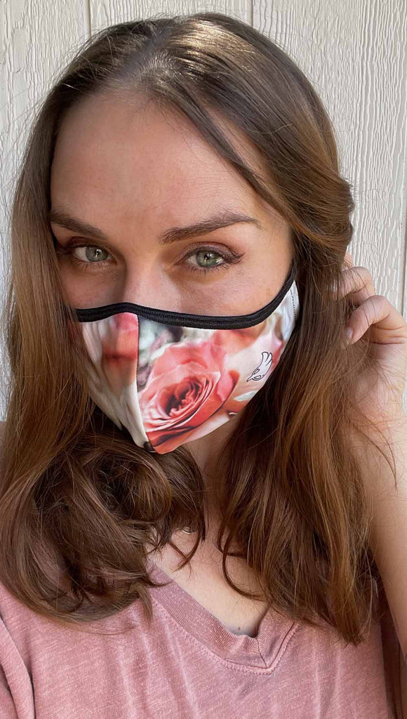 Girl wearing bodacious bouquet adjustable face mask - with soft cream, peach and warm pink roses