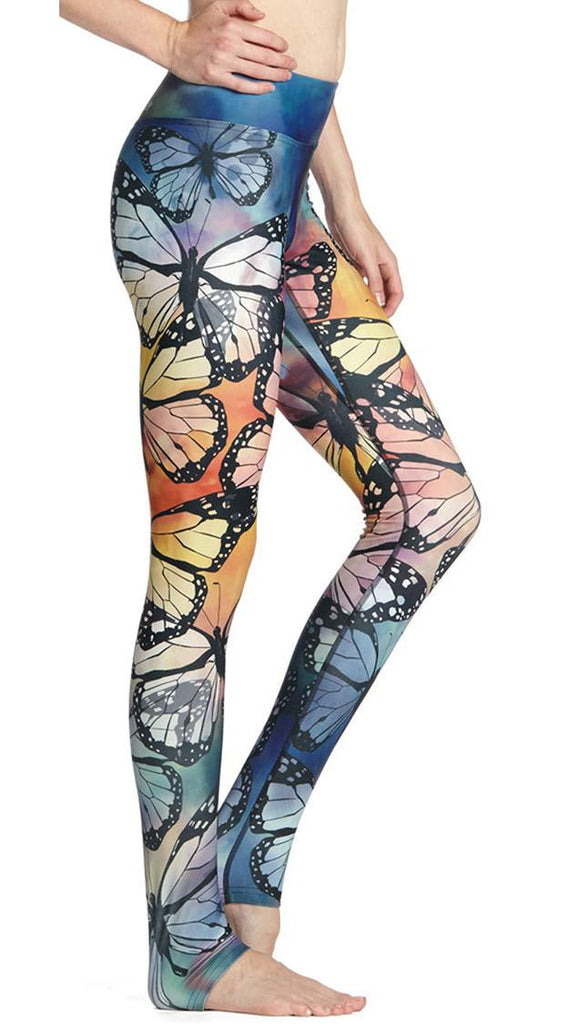 right side view of model wearing colorful butterfly themed printed full length triathlon leggings