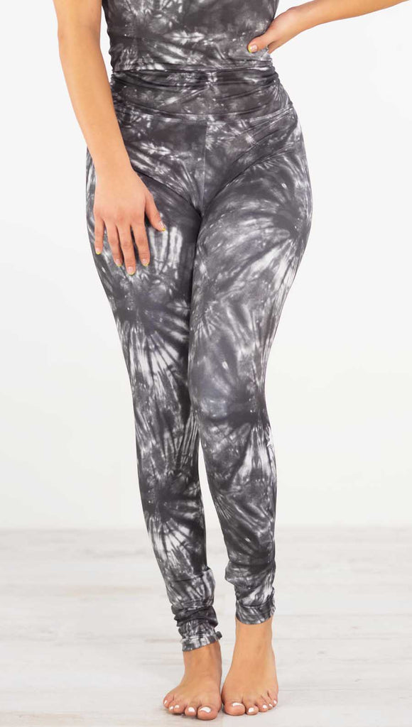 Front view of model wearing the charcoal spiral athleisure leggings. They are in a charcoal color with white tie dye spirals throughout the leggings.