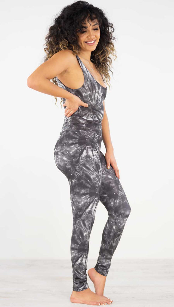 Right side view of model wearing the charcoal spiral athleisure leggings. They are in a charcoal color and have white tie dye spirals throughout the leggings.