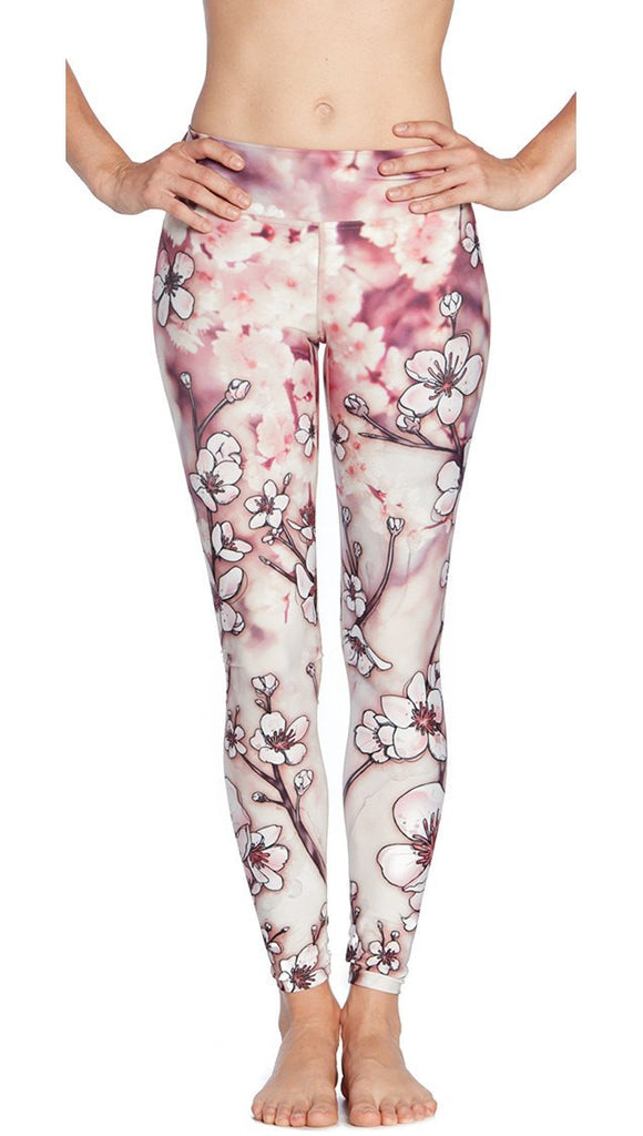 closeup front view of model wearing cherry blossom themed printed full length leggings
