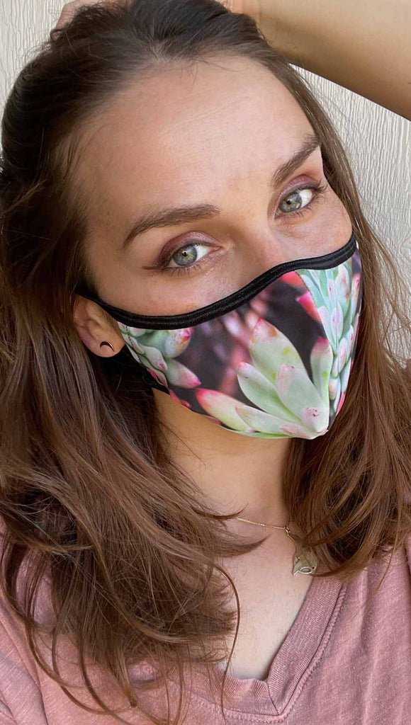 Girl wearing coachella sunset adjustable face mask with bright succulent inspired print - featuring bright green and hot pink tones
