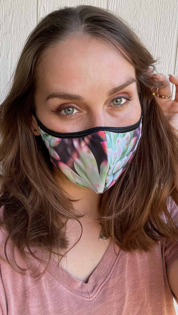 Girl wearing coachella sunset adjustable face mask with bright succulent inspired print - featuring bright green and hot pink tones