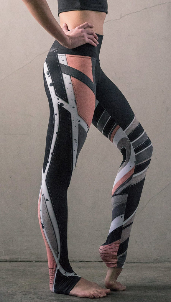 closeup right side view of model wearing striped coral moto themed printed full length leggings