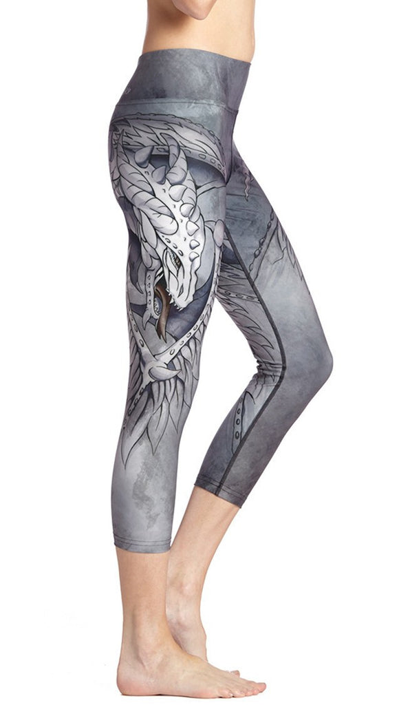 close up right side view of model wearing fantasy dragon themed printed capri leggings