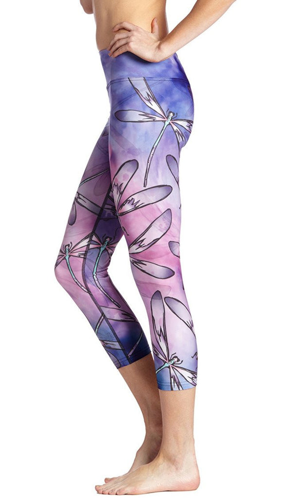  close up side view of model wearing purple and pink dragonfly themed printed capri leggings