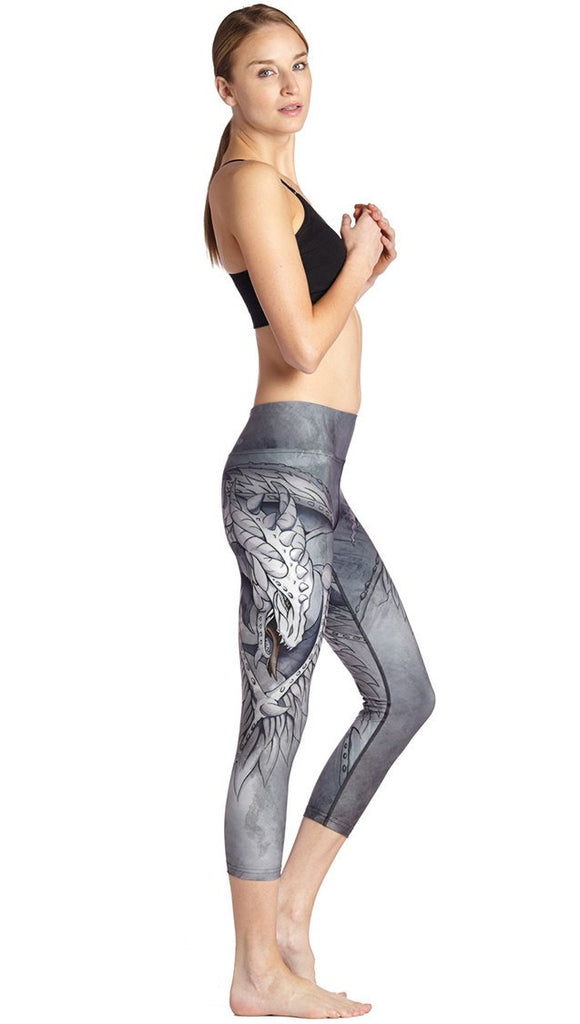 right side view of model wearing fantasy dragon themed printed capri leggings
