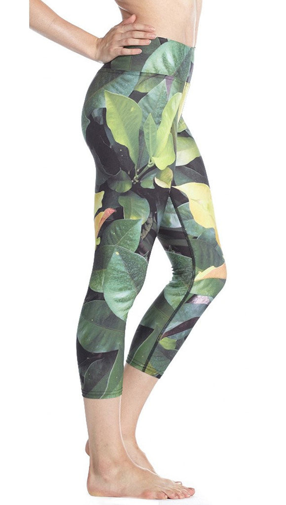 close up right side view of model wearing tropical foliage themed printed capri leggings