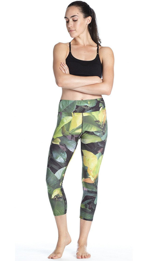 front view of model wearing tropical foliage themed printed capri leggings