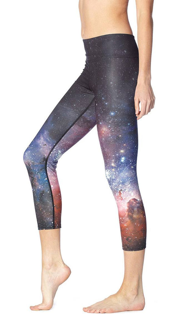 close up left side view of model wearing galaxy themed printed capri leggings
