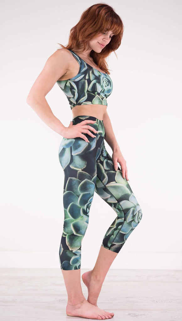 Right view of model wearing black capri leggings with green succulent plants throughout