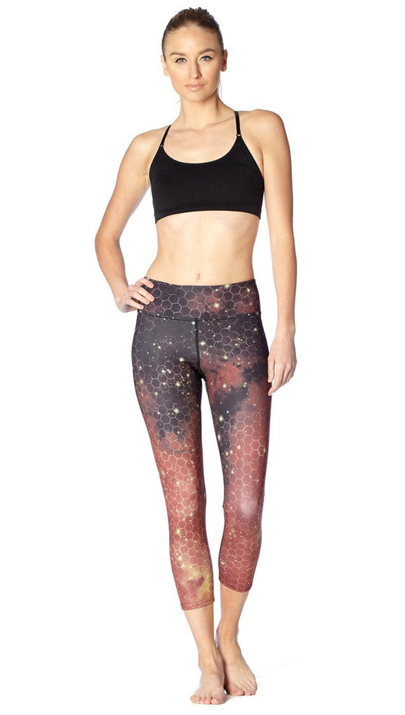 front view of model wearing honeycomb galaxy themed printed capri leggings