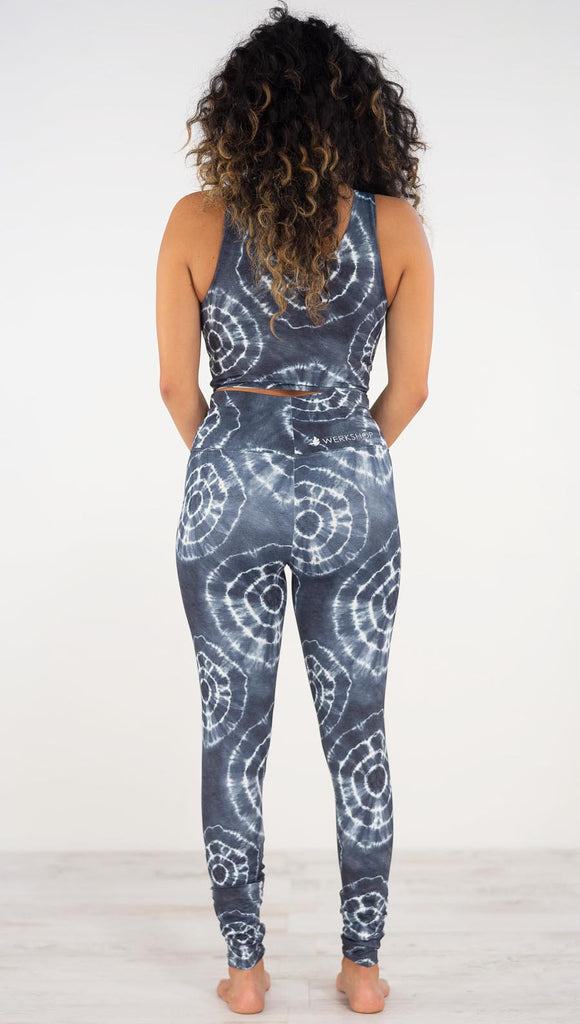 Back view of model wearing the indigo circles athleisure leggings. they are in a indigo color and have white tie dye circles throughout. Each circle has a smaller circle within each other. 