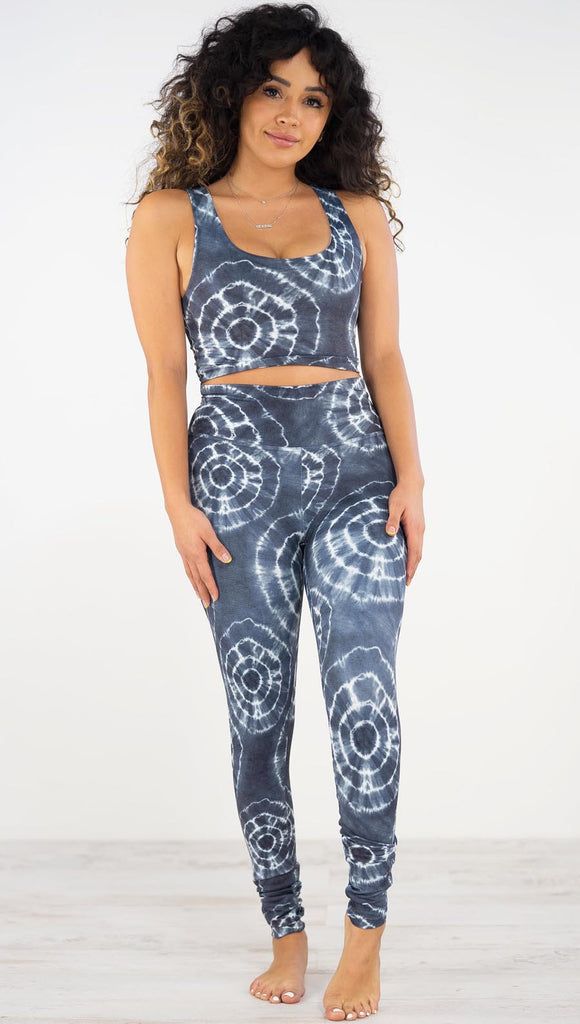 Front view of model wearing the indigo circles athleisure leggings. They are in a indigo color and have white tie dye circles throughout. Each circle has a smaller circle within each other.