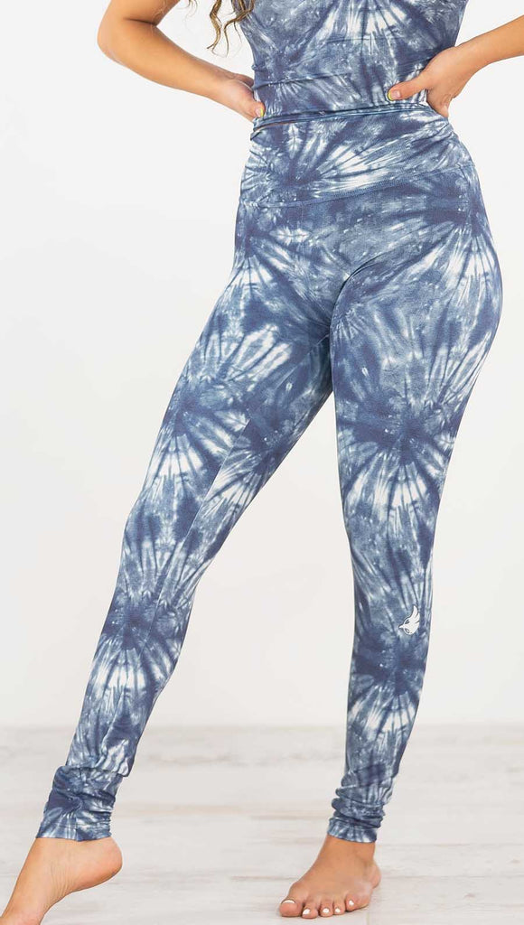 Front view of model wearing the indigo spiral athleisure leggings. They are in a indigo color and have white tie dye spirals throughout the leggings.