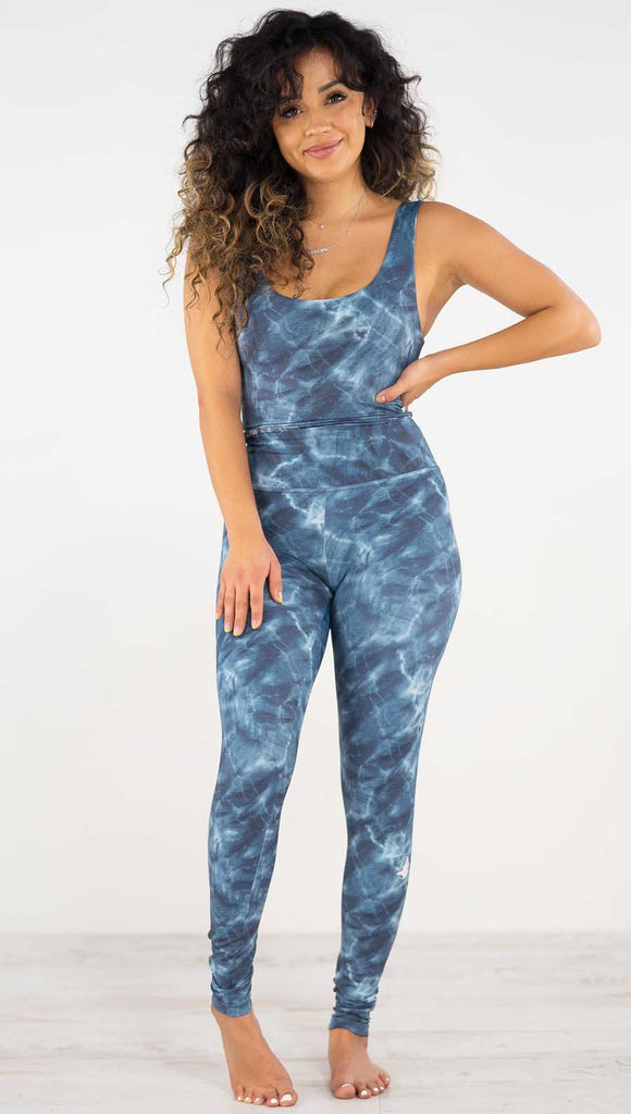 Front view of model wearing the indigo waves athleisure leggings. They are in a indigo color and have a water waves print in white and navy color throughout.
