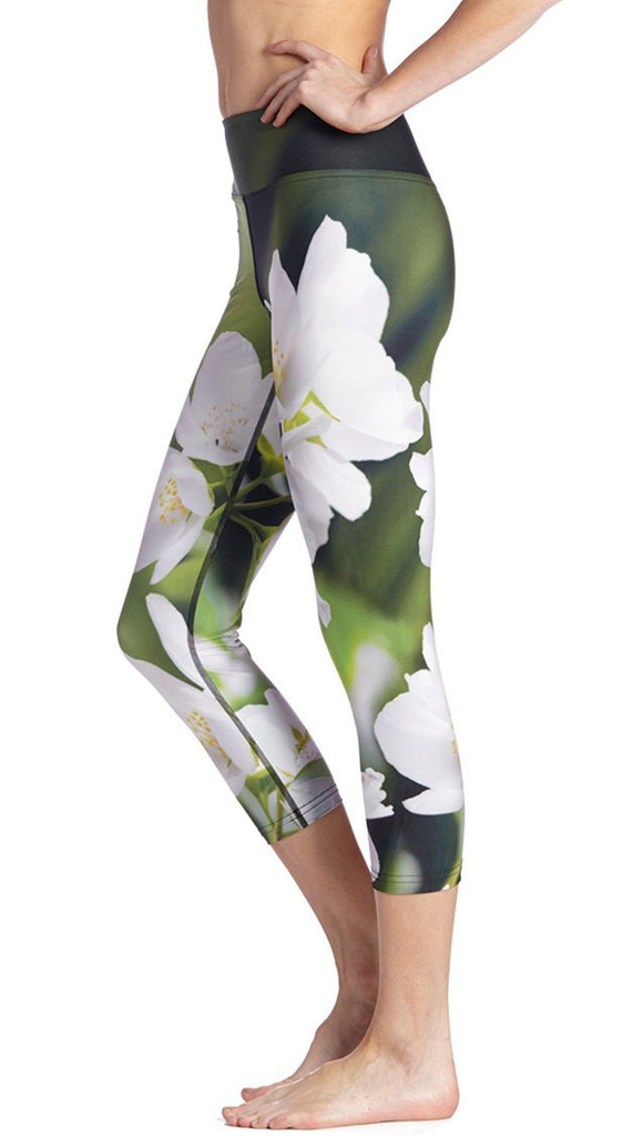 close up left side view of model wearing white jasmine flower themed printed capri leggings