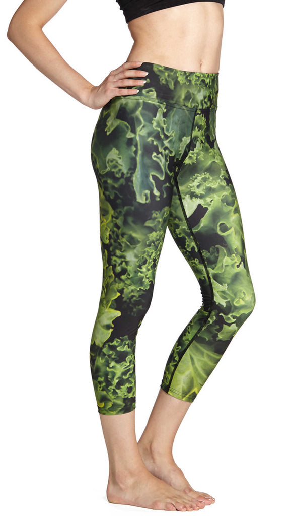 Model wearing leggings printed with a large macro image of fresh green kale.