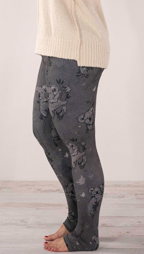 Left side view of model wearing koala leggings with tree branches and leaves