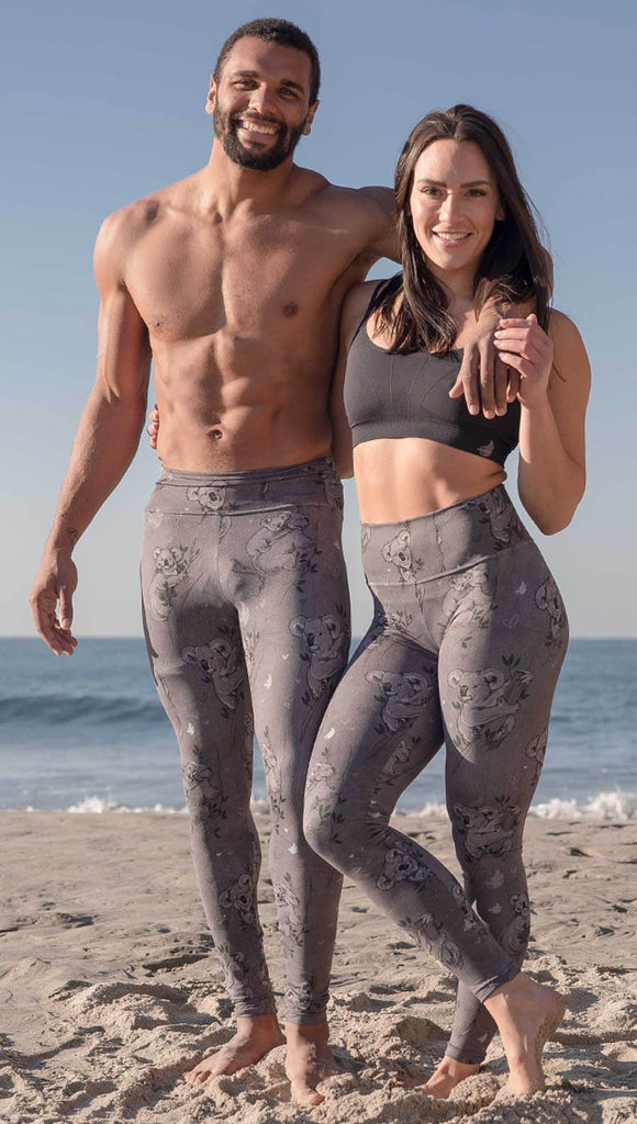 Male and female models standing side by side wearing koala leggings with tree branches and leaves