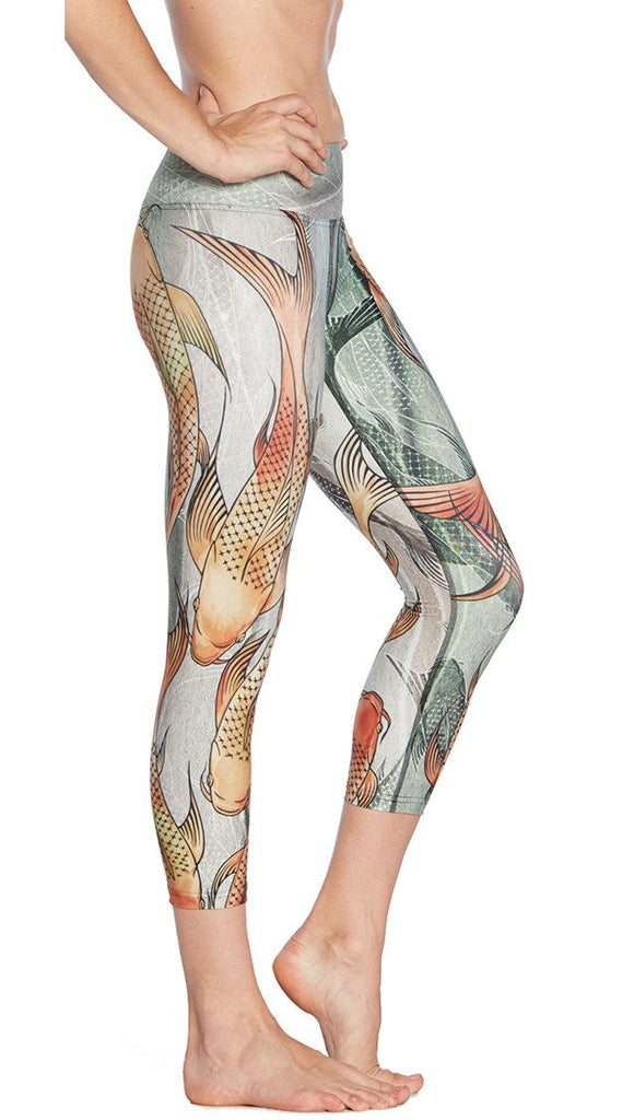 close up right side view of model wearing koi fish themed printed capri leggings