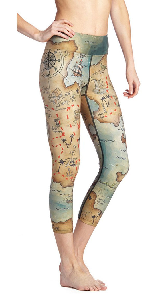 close up side view of model wearing treasure map themed printed capri leggings