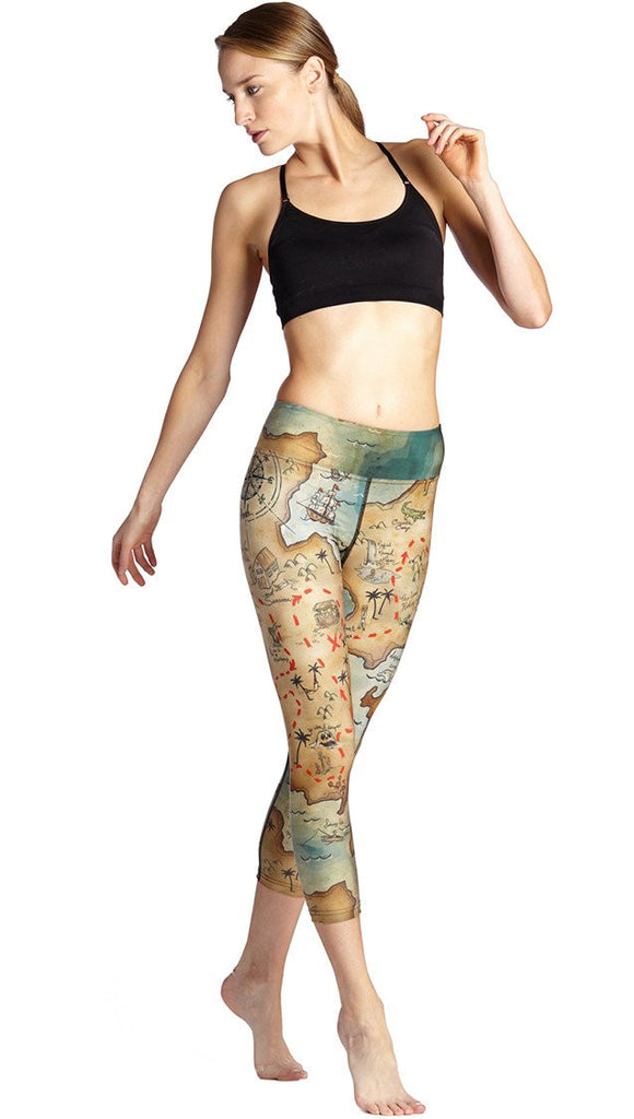 front view of model wearing treasure map themed printed capri leggings