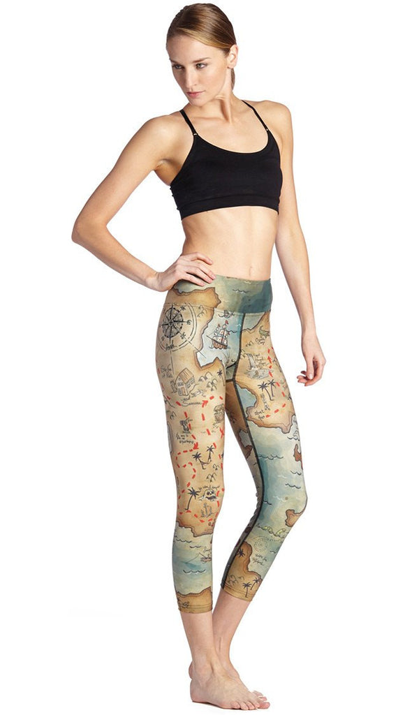right side view of model wearing treasure map themed printed capri leggings