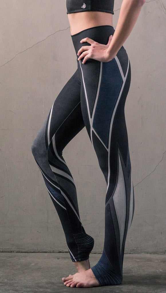 close up left side view of model wearing midnight blue colored motocross inspired printed full length leggings