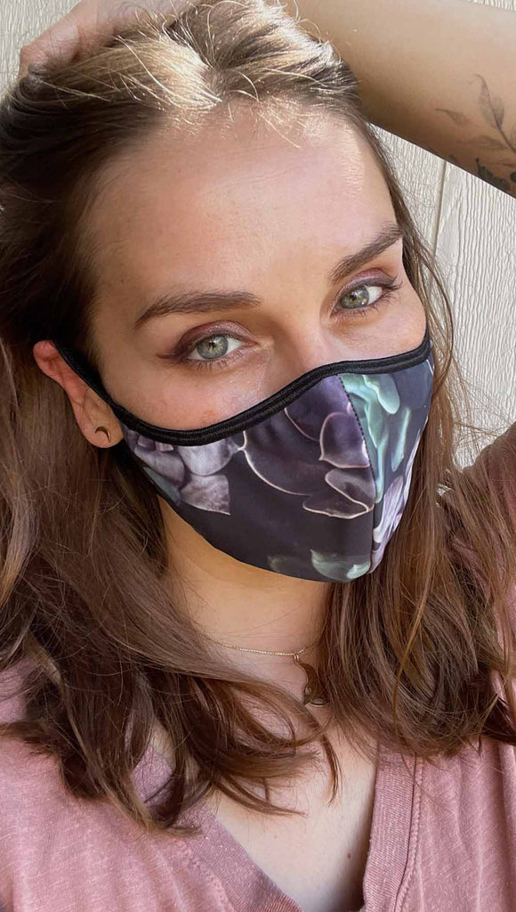 Girl wearing midnight garden adjustable face mask with succulent inspired print - with soft purple and green tones