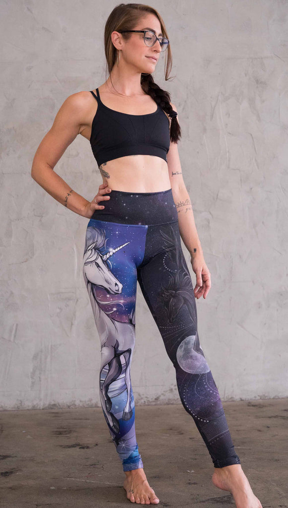 right view of model wearing the nightmare mashup leggings in a blue and dark purple. This leg has a large white unicorn 