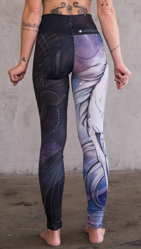 Back view of model wearing the nightmare mashup leggings in a blue and dark purple. One leg has a white unicorn and the other leg has a black horse with wings