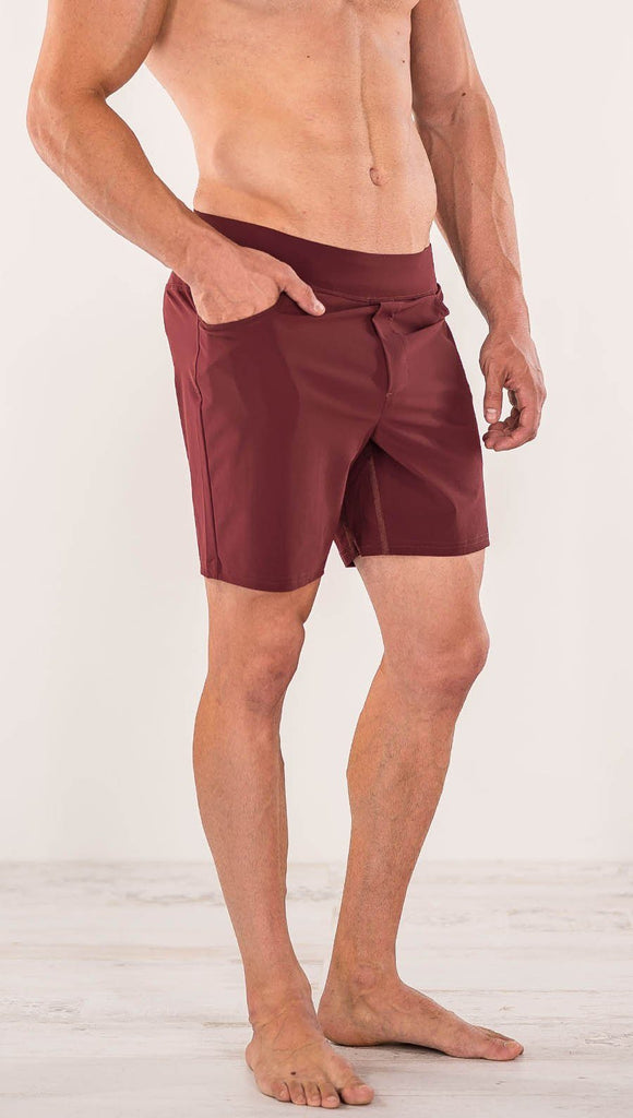 Close up right side view of model wearing men's oxblood performance shorts with slim fit