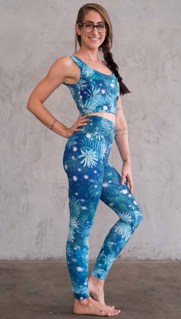 Right view of model wearing blue holiday leggings with flocked pine