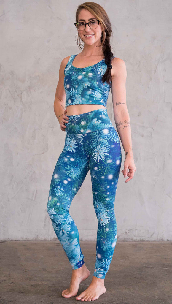 Front left view of model wearing blue holiday leggings with flocked pine
