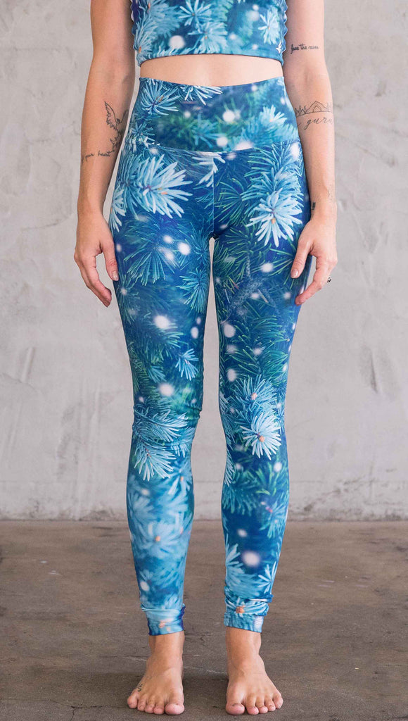Front view of model wearing blue holiday leggings with flocked pine