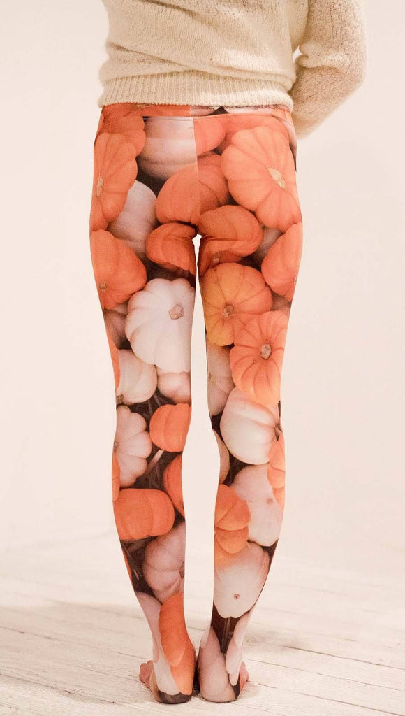 Back view of model wearing white and orange pumpkin leggings